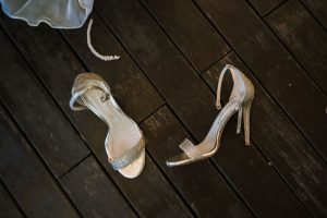 fotografía sandalias de novia sobre superficie de madera