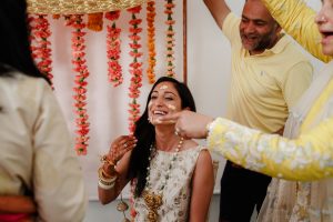 destination weddings fotografía vasudha en la ceremonia sangeet rodeada de familiares y amigos